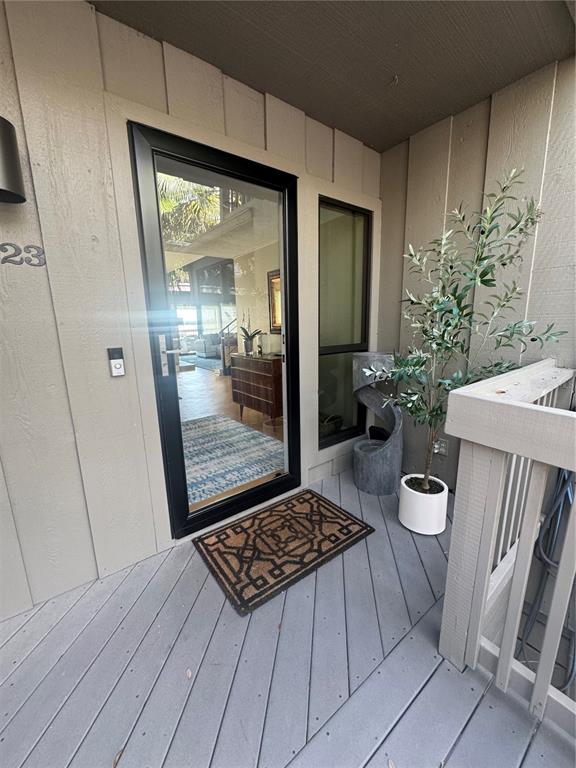 A front entryway features a glass door, a patterned doormat, and a potted olive tree — 1323 LANDINGS DRIVE UNIT 12, SARASOTA, FL
