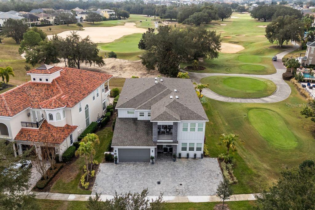 An aerial view shows two adjacent houses situated next to a golf course fairway — 7442 GATHERING COURT, KISSIMMEE, FL