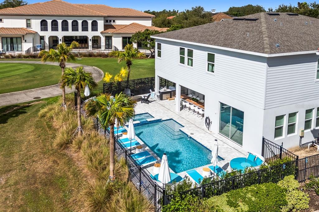 An aerial view of a two-story house with a backyard pool and patio area — 7442 GATHERING COURT, KISSIMMEE, FL
