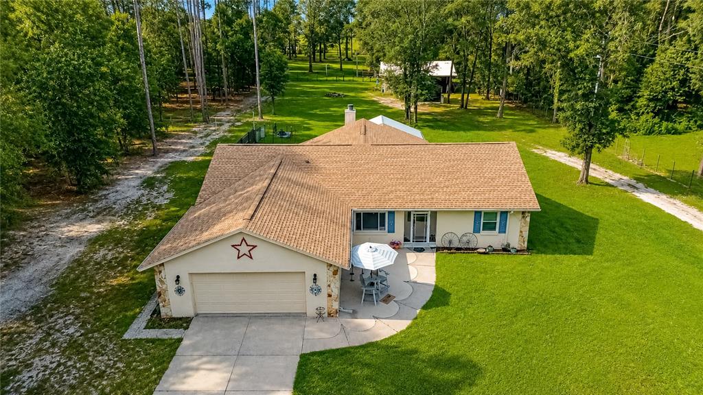 An aerial view shows a single-story house with a tan roof, garage, and patio — 15970 NW 53RD STREET, MORRISTON, FL