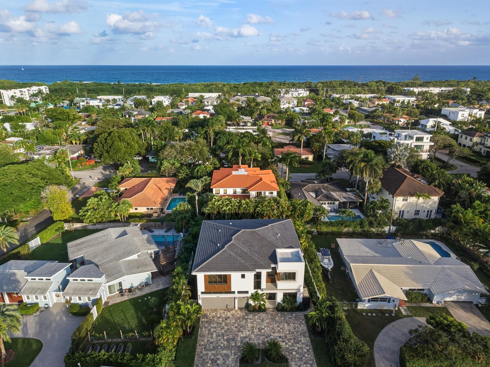 An aerial view shows a modern two-story house with a gray roof in a neighborhood — 450 NE Spanish Court, Boca Raton FL 33432, BOCA RATON, FL
