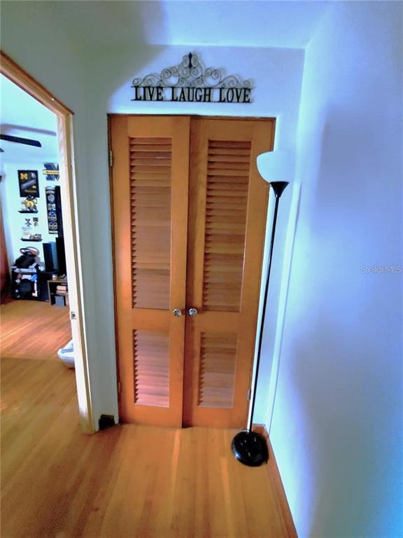 A hallway features wooden louvered closet doors, a floor lamp, and a wall sign — 448 N KANSAS AVENUE, DELAND, FL
