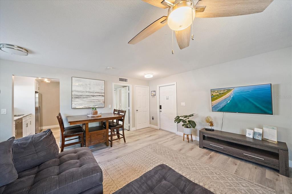 A living room features a gray sectional, a dining table, and a wall-mounted television — 3710 IROQUOIS AVENUE, SARASOTA, FL