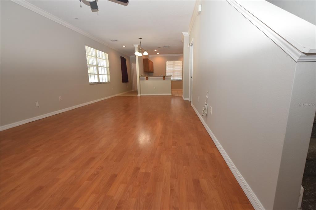An open-concept living area features light-colored walls, wood-look flooring, and a kitchen with a breakfast bar — 4901 ELIZABETH ANNE CIRCLE, TAMPA, FL
