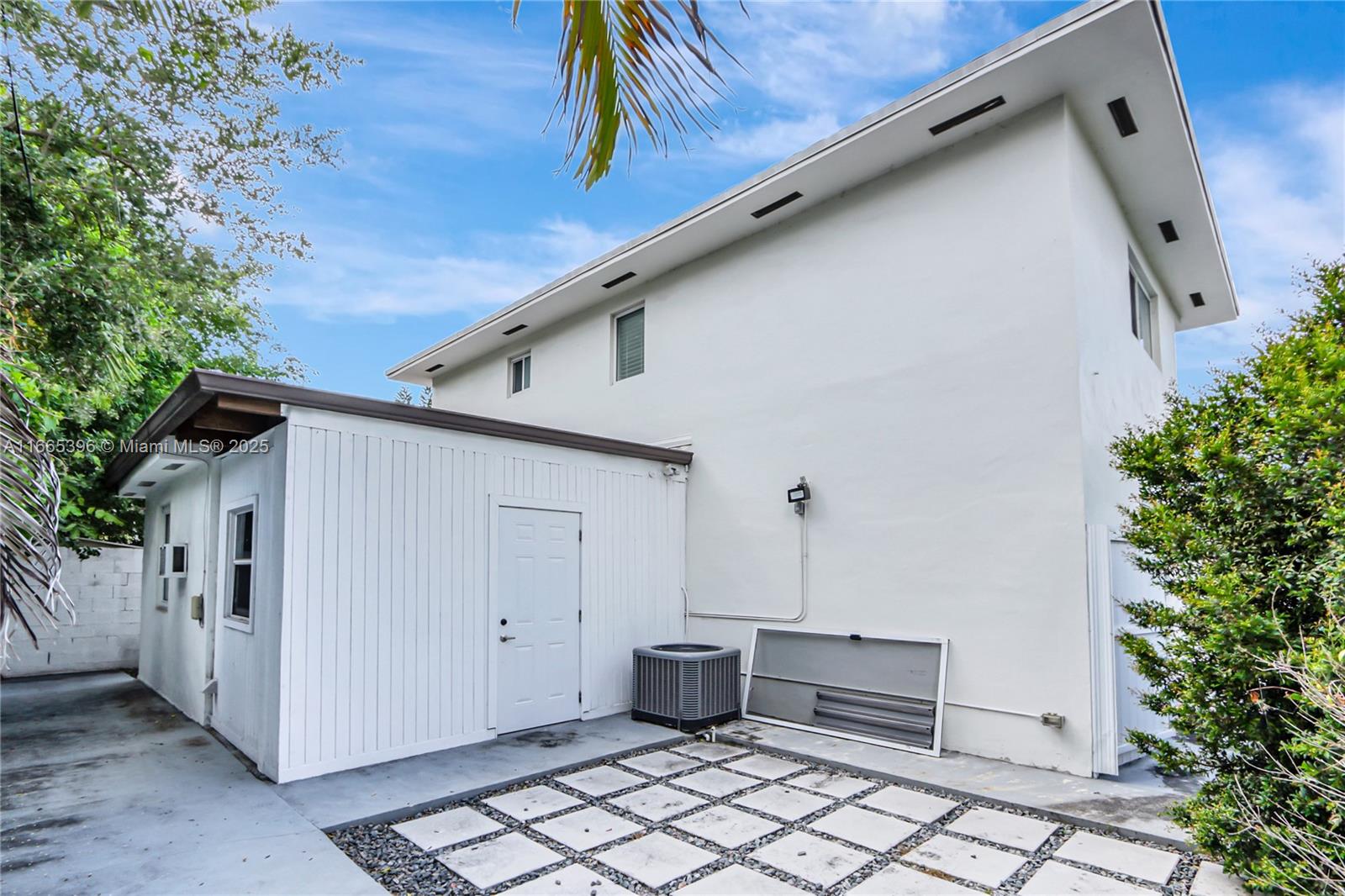 The exterior of a two-story white house features a small attached structure and a patio — 1359 SW 11th St, Miami FL 33135, MIAMI, FL