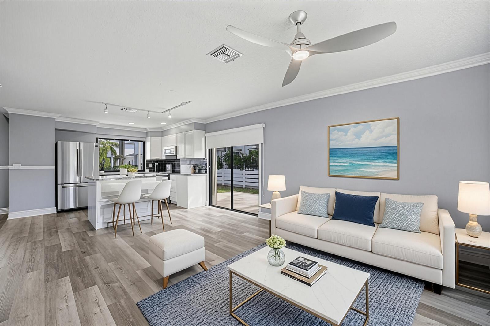 A living room and kitchen area with light wood floors, white cabinetry, and a sofa — 324 W Pine Street # 11, Lantana FL 33462, LANTANA, FL