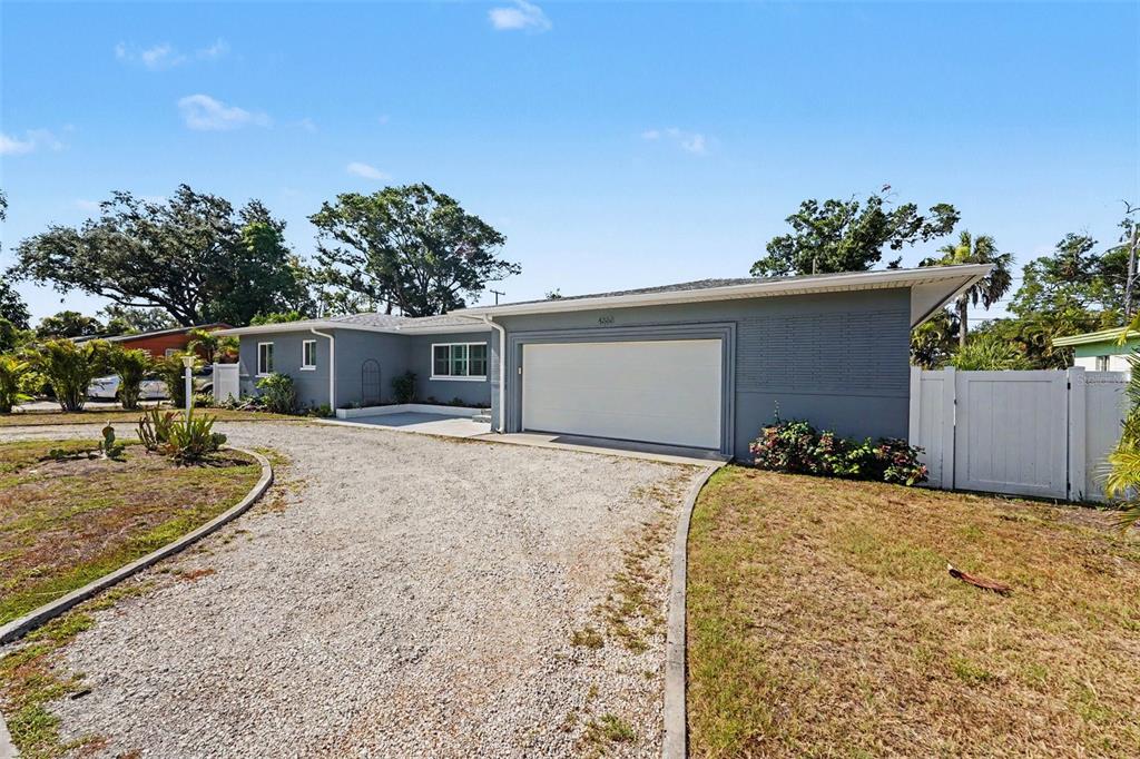 A single-story gray house with a gravel driveway and an attached two-car garage — 4660 22ND AVENUE S, ST PETERSBURG, FL