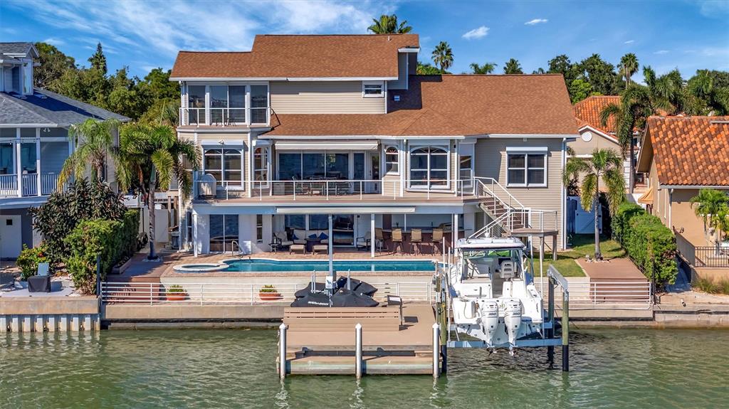 A multi-story waterfront house features a swimming pool, a private dock, and a boat lift — 5918 SKIMMER POINT BOULEVARD S, GULFPORT, FL