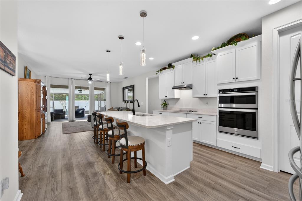 A modern kitchen with white cabinets, a large island, and stainless steel appliances — 13017 SATIN LILY DRIVE, RIVERVIEW, FL