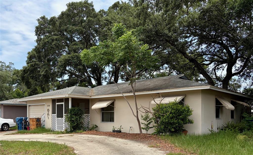 A sunroom features tile flooring, a large sectional sofa, a television, and a ceiling fan — 7179 SPRING HILL DRIVE, SPRING HILL, FL