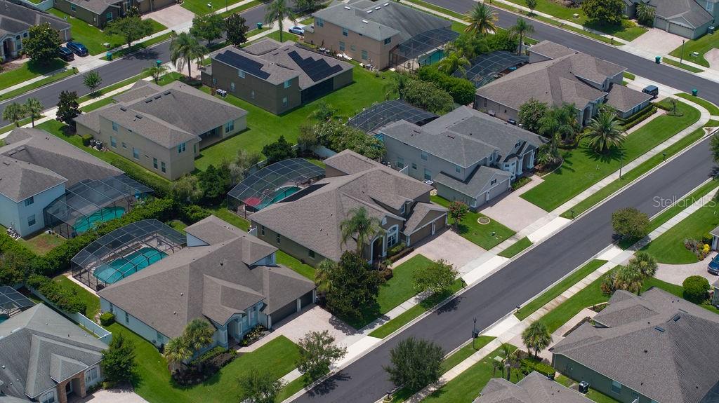 An aerial view shows several suburban houses with swimming pools and screened lanais — 13624 LARSEN LANE, WINTER GARDEN, FL