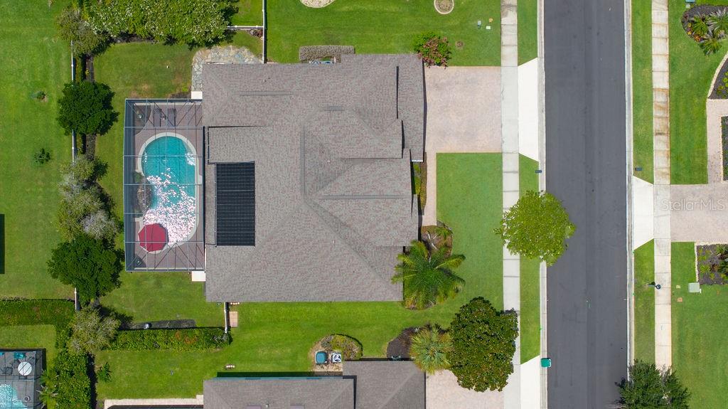 An aerial view shows a house with a screened-in pool and a dark solar panel array — 13624 LARSEN LANE, WINTER GARDEN, FL