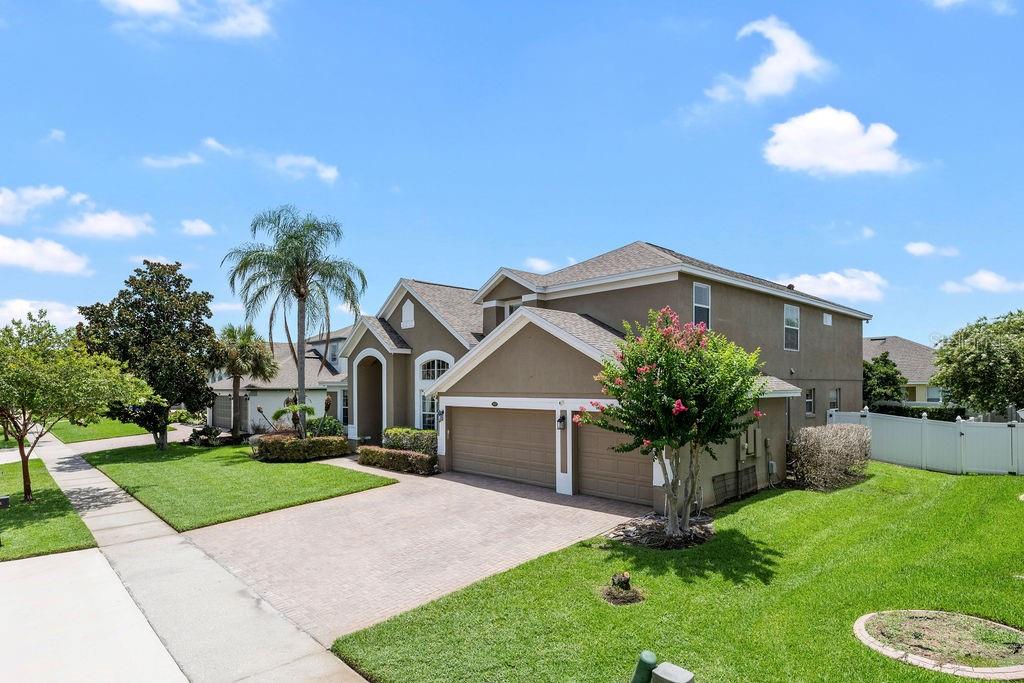 A two-story suburban house with a paved driveway, a two-car garage, and a green lawn — 13624 LARSEN LANE, WINTER GARDEN, FL