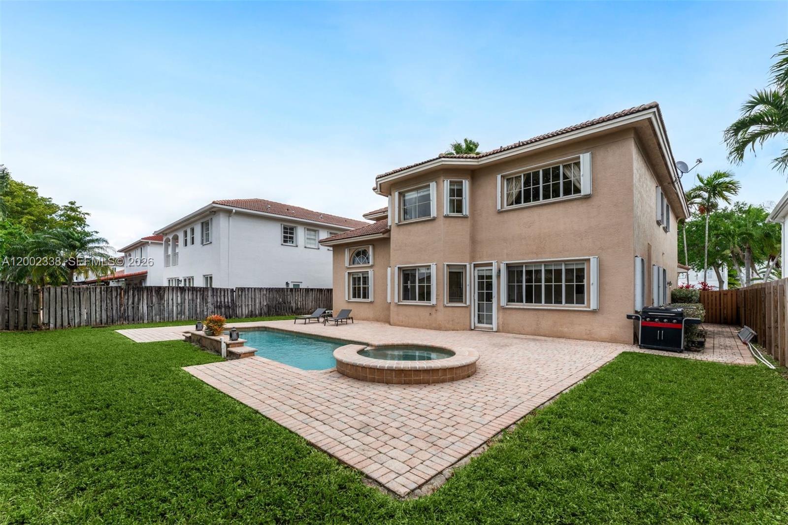 The backyard features a swimming pool, a raised spa, and a paved patio area — 6914 NW 113th Pl, Doral FL 33178, DORAL, FL