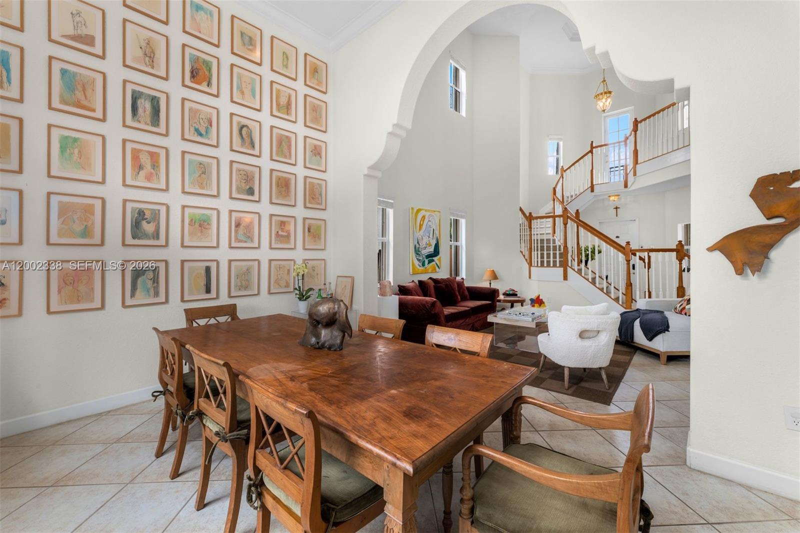 A dining room with a large wooden table and a wall gallery of framed art — 6914 NW 113th Pl, Doral FL 33178, DORAL, FL