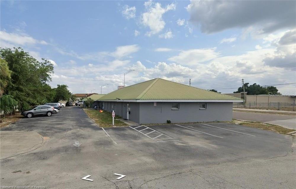 A single-story commercial building with a green metal roof and a paved parking lot — 746 US HIGHWAY 27 N, AVON PARK, FL