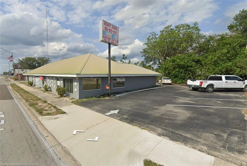 A gray commercial building with a metal roof and a parking lot sits outdoors — 746 US HIGHWAY 27 N, AVON PARK, FL