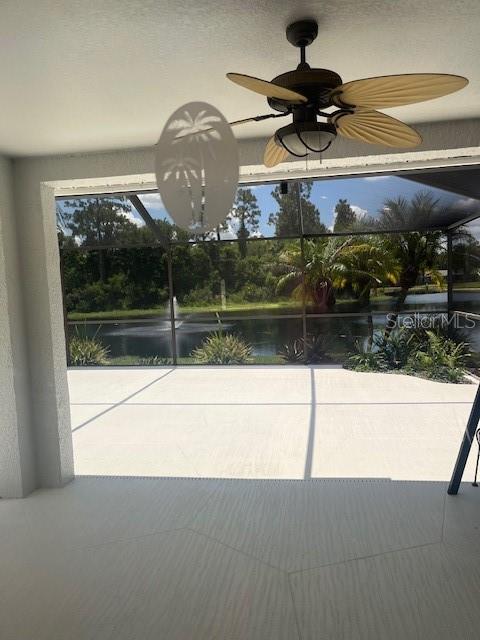 A covered patio with a ceiling fan overlooks a screened-in pool area and a pond — 8144 SANGUINELLI ROAD, LAND O LAKES, FL