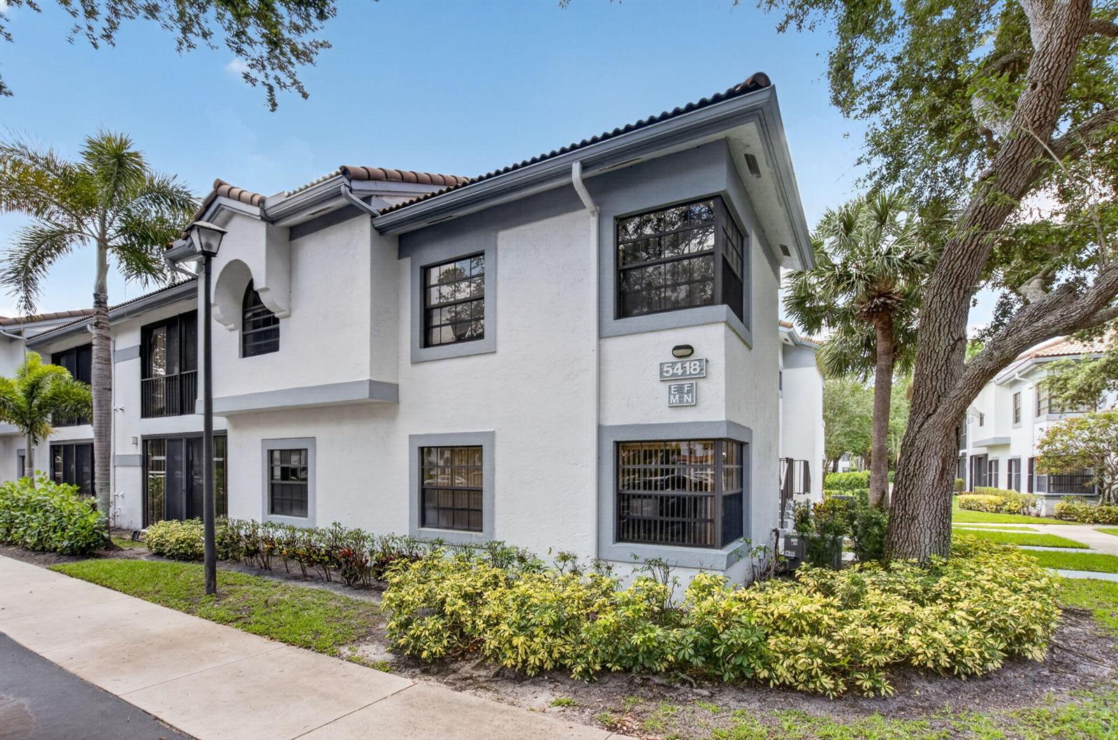 A two-story white stucco apartment building with dark trim and a tile roof — 5418 Firenze Drive # F, Boynton Beach FL 33437, BOYNTON BEACH, FL