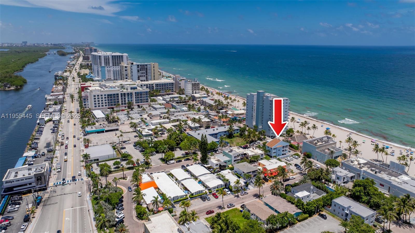 An aerial view shows a coastal neighborhood with a red arrow pointing to a building — 311 N Surf Rd, Hollywood FL 33019, HOLLYWOOD, FL
