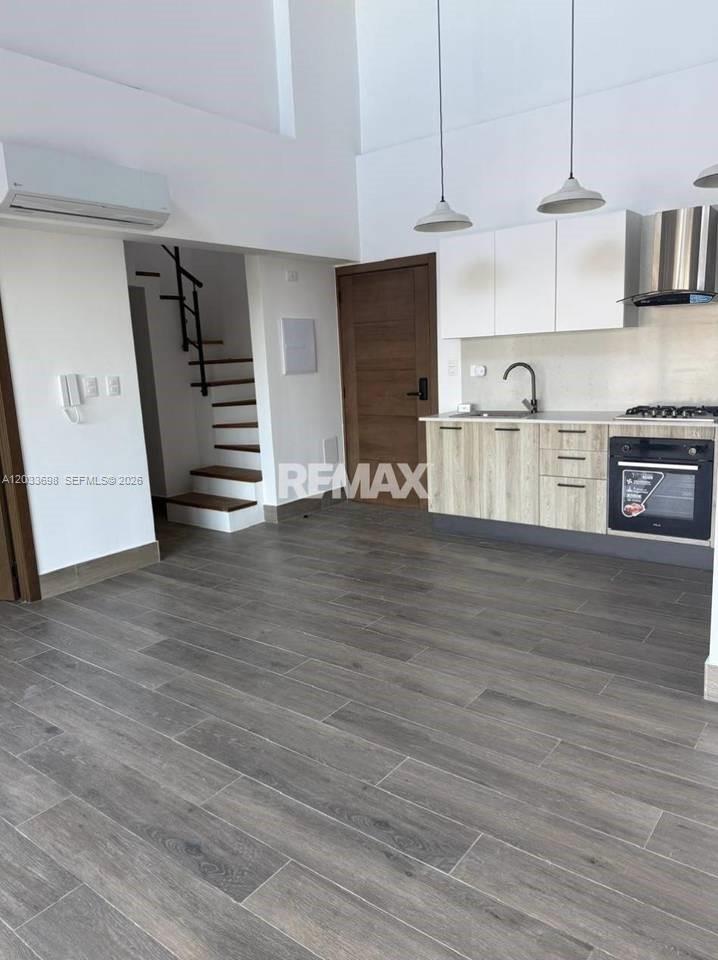A modern kitchen with light wood cabinets and a staircase is visible in this room — fh9m Cap Cana # 515, 1 1, 1