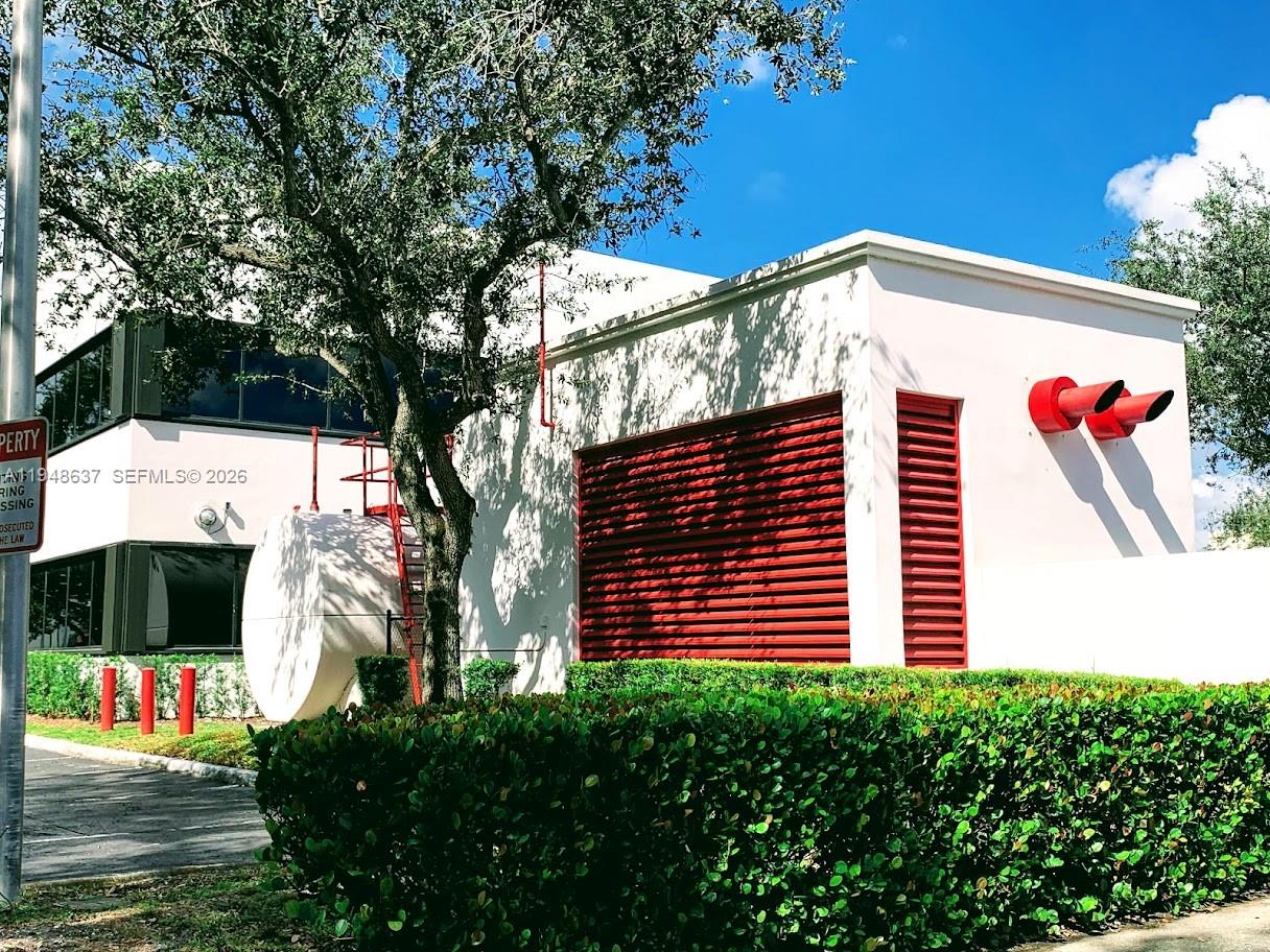 The exterior of a white commercial building features red louvers, a large tank, and red vents — 14261 Commerce Way, Miami Lakes FL 33016, MIAMI LAKES, FL