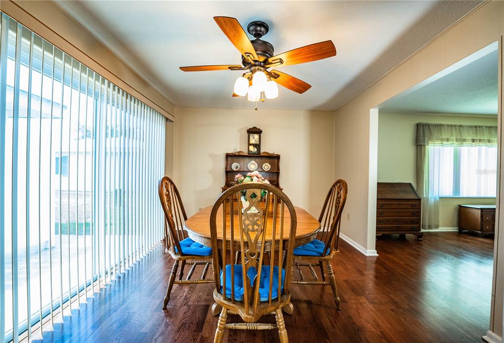 A single-story house exterior features a covered entryway, a small garden bed, and pink shutters — 652 COTTAGE LANE, LAKELAND, FL