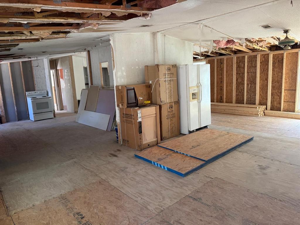 An interior view of a room under construction with exposed ceiling joists and plywood flooring — 13395 NE 65TH COURT, CITRA, FL