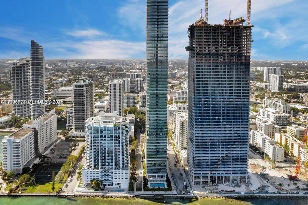 An aerial view shows a coastal city skyline featuring several high-rise buildings under construction — 788 NE 23rd St # 1402, Miami FL 33137, MIAMI, FL