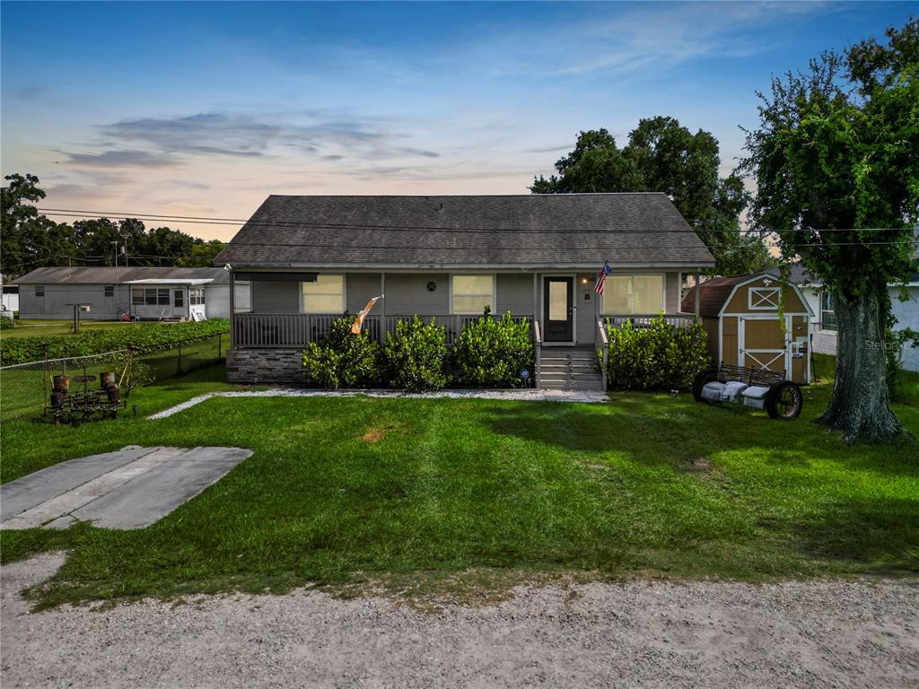 A single-story house with a front porch, a gravel driveway, and a small storage shed — 2001 W BALL STREET, PLANT CITY, FL