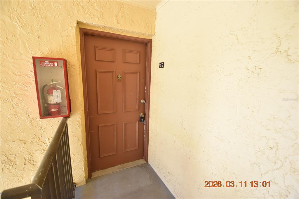 A brown door labeled C9 is located next to a wall-mounted fire extinguisher — 3910 44TH STREET N UNIT C9, ST PETERSBURG, FL