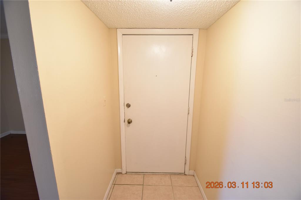 A plain white door with a deadbolt and knob is centered in a small entryway — 3910 44TH STREET N UNIT C9, ST PETERSBURG, FL