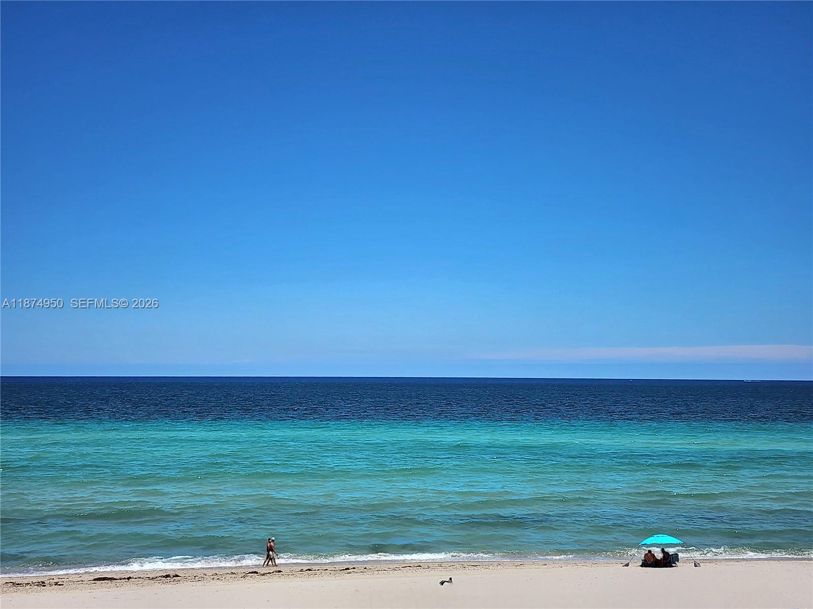A wide, sandy beach meets turquoise and deep blue ocean under a clear sky — 3505 S Ocean Dr # 312, Hollywood FL 33019, HOLLYWOOD, FL