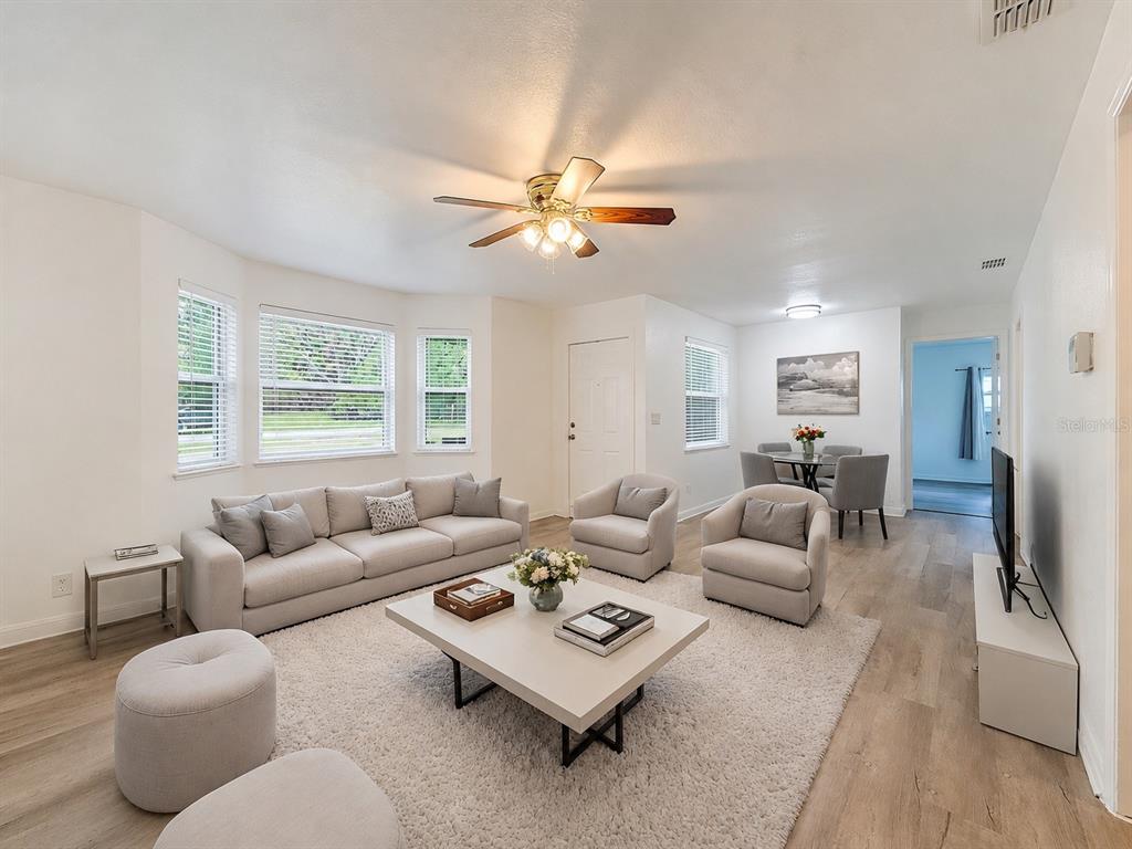 A dining room features a wooden table with six chairs, a rug, and a window — 1926 MEADOWRIDGE DRIVE, VALRICO, FL