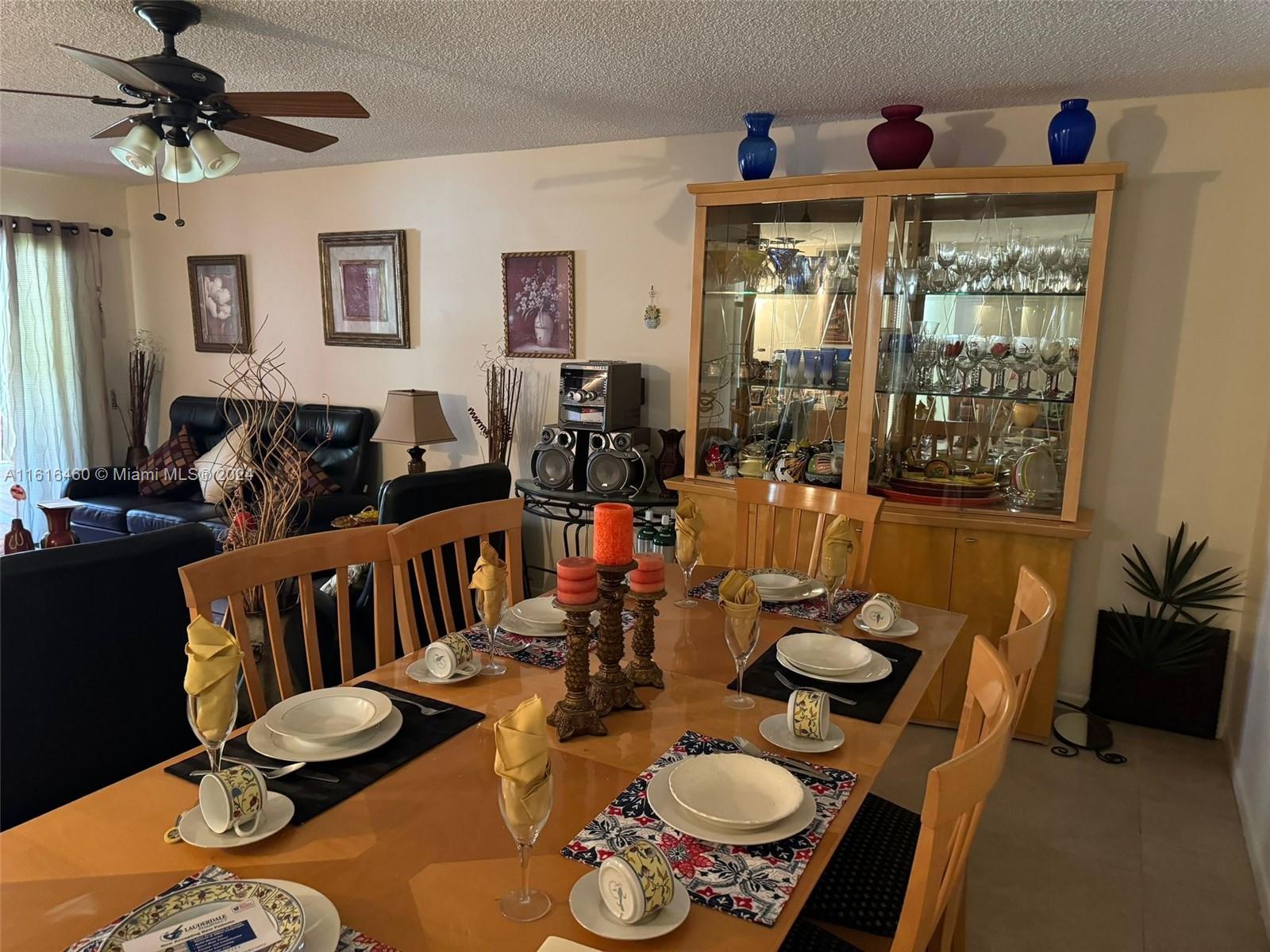 A dining room features a wooden table set for six, a china cabinet, and a ceiling fan — 4047 NW 16th St # 110, Lauderhill FL 33313, LAUDERHILL, FL
