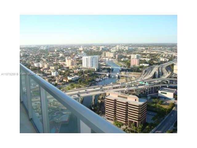 A high-angle view from a balcony overlooking a city skyline, highway, and river — 185 SW 7th St # 1909, Miami FL 33130, MIAMI, FL