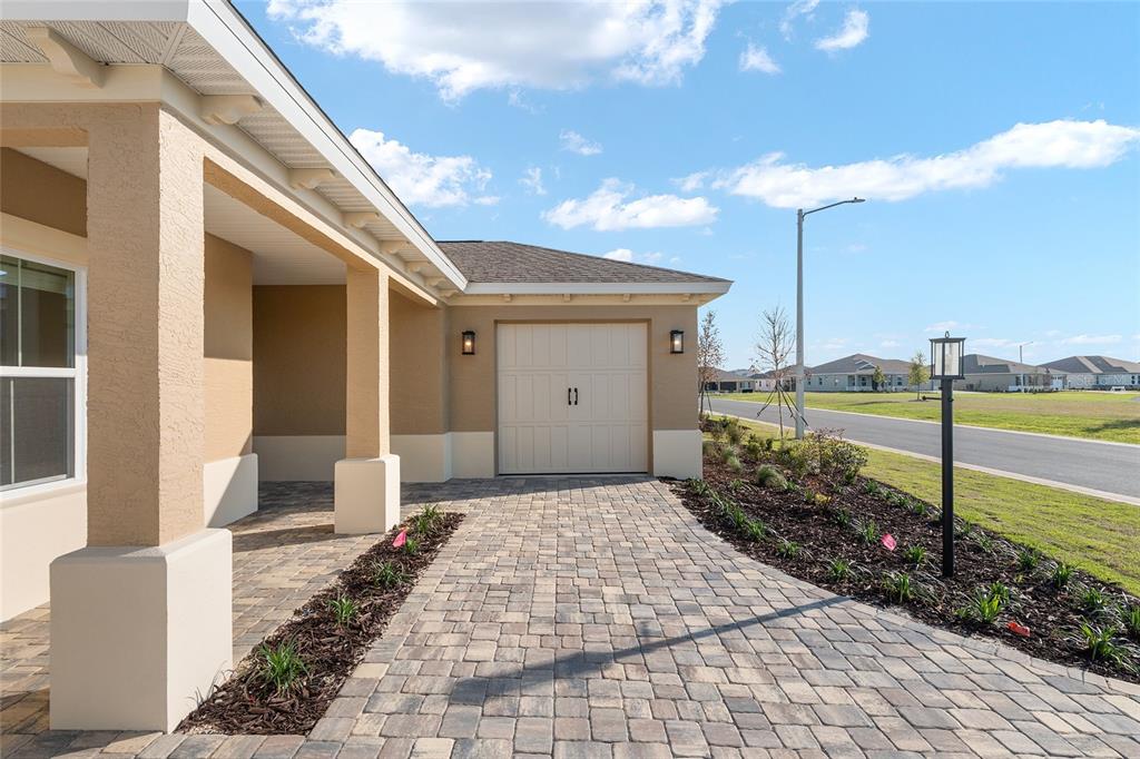 A paved driveway leads to a single-car garage and a covered porch on a house — 8515 SW 101ST TERRACE, OCALA, FL
