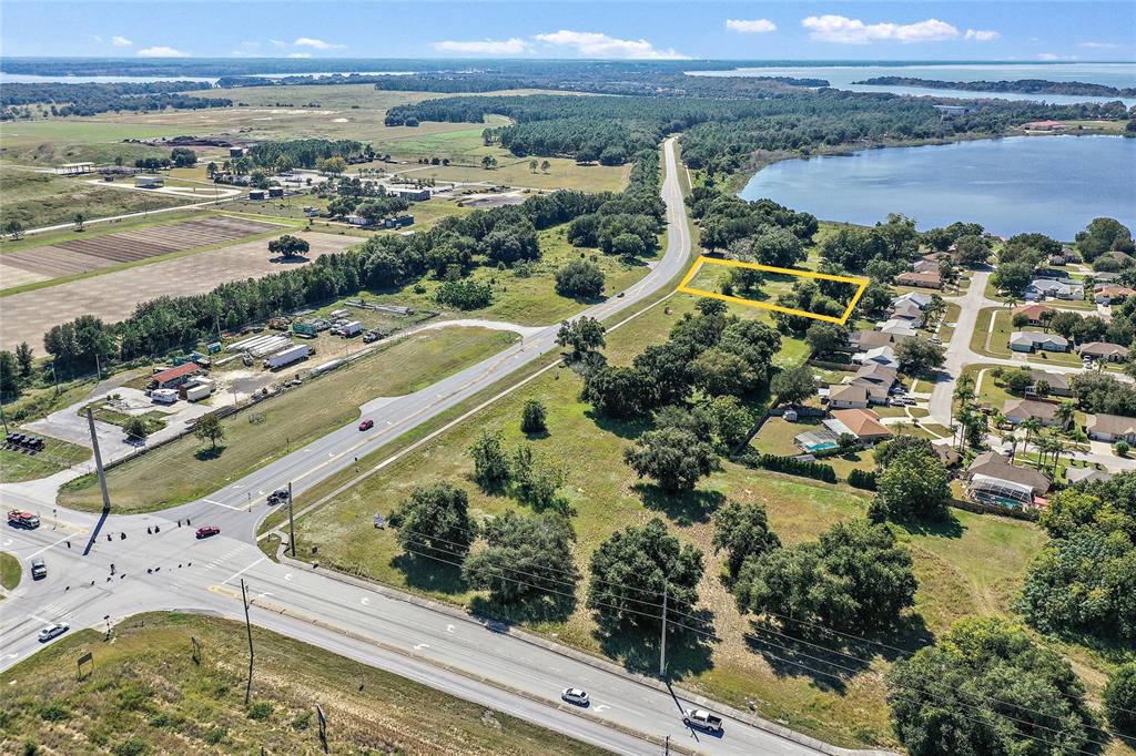 An aerial view shows a rectangular plot of land outlined in yellow near a road — CR-448 Lot 4, TAVARES, FL