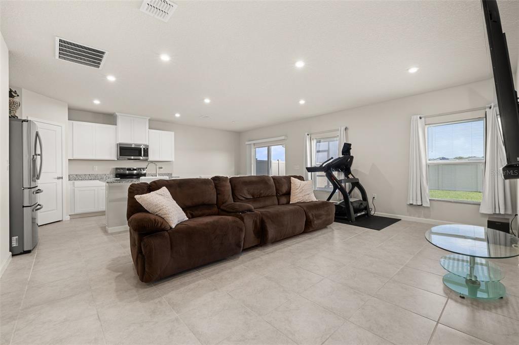 A living room with tile flooring, a brown sectional sofa, and an open-concept kitchen — 1620 TEXAS AVENUE, SUMTERVILLE, FL