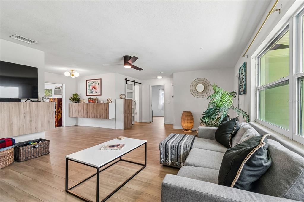 A living room with light wood flooring, a grey sofa, and a white coffee table — 11555 63RD AVENUE, SEMINOLE, FL