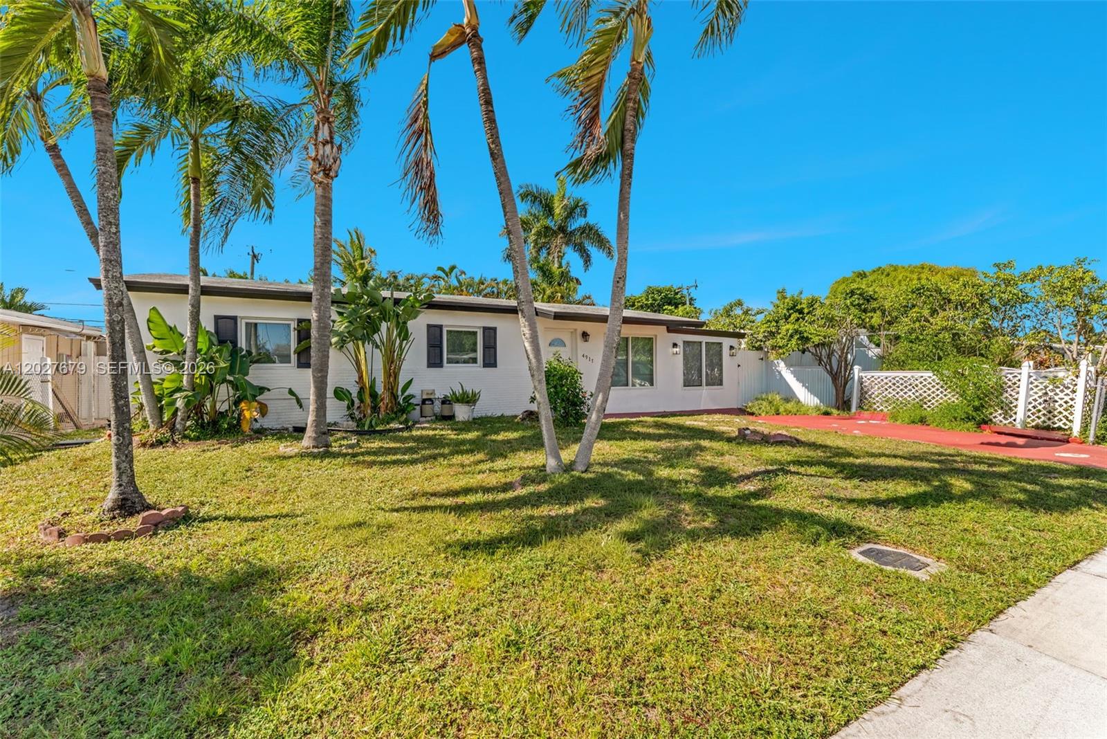 A single-story white house with a red driveway and palm trees in the front yard — 4917 SW 43rd Ter # A, Dania Beach FL 33314, DANIA BEACH, FL