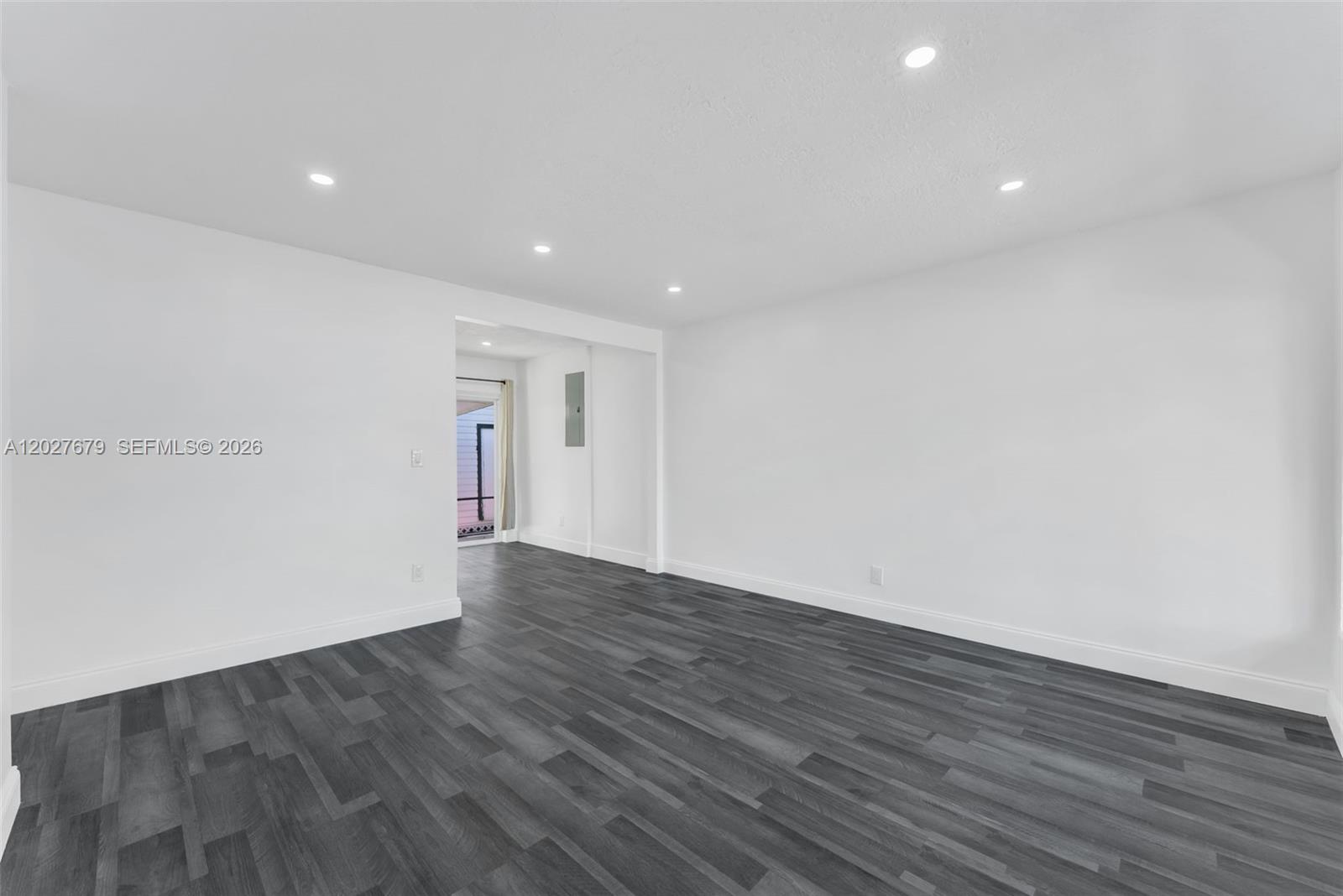 An empty room features white walls, recessed lighting, and dark gray wood-look flooring — 4917 SW 43rd Ter # A, Dania Beach FL 33314, DANIA BEACH, FL