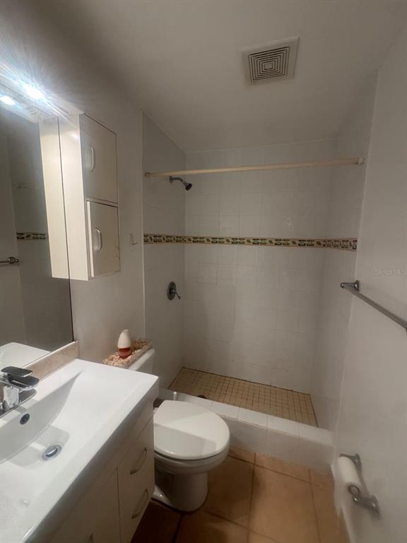 A bathroom features a white vanity, a toilet, and a tiled walk-in shower — II LOS PARILLAS UNIT 3501, LOIZA, PR