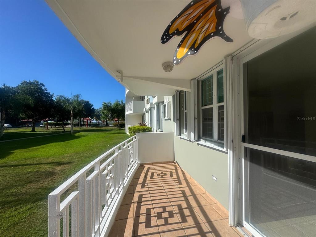A balcony with tile flooring, a white railing, and a butterfly decoration on the ceiling — II LOS PARILLAS UNIT 3501, LOIZA, PR