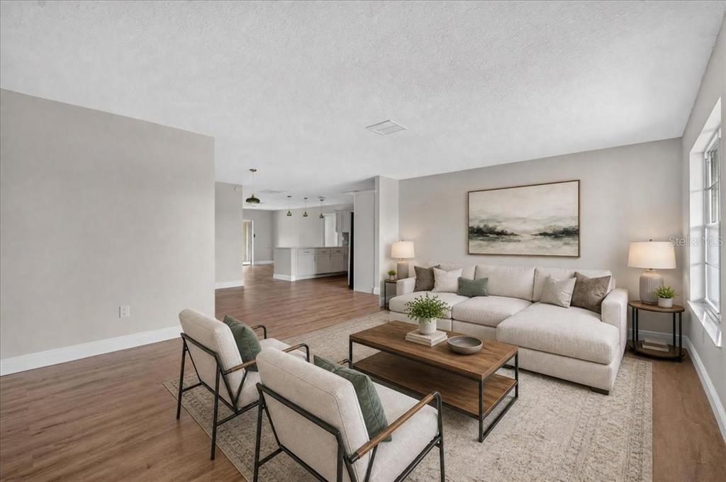 A living room with light-colored furniture, a wooden coffee table, and wood-look flooring — 1201 WILD FEATHER LANE, SUN CITY CENTER, FL