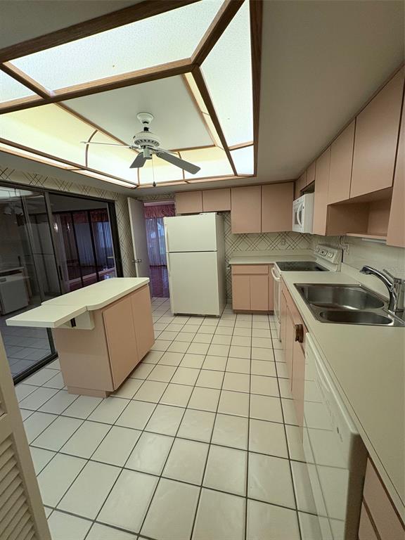 A kitchen features pink cabinets, white appliances, a central island, and a large ceiling light — 14111 CYPRESS CIRCLE, TAMPA, FL