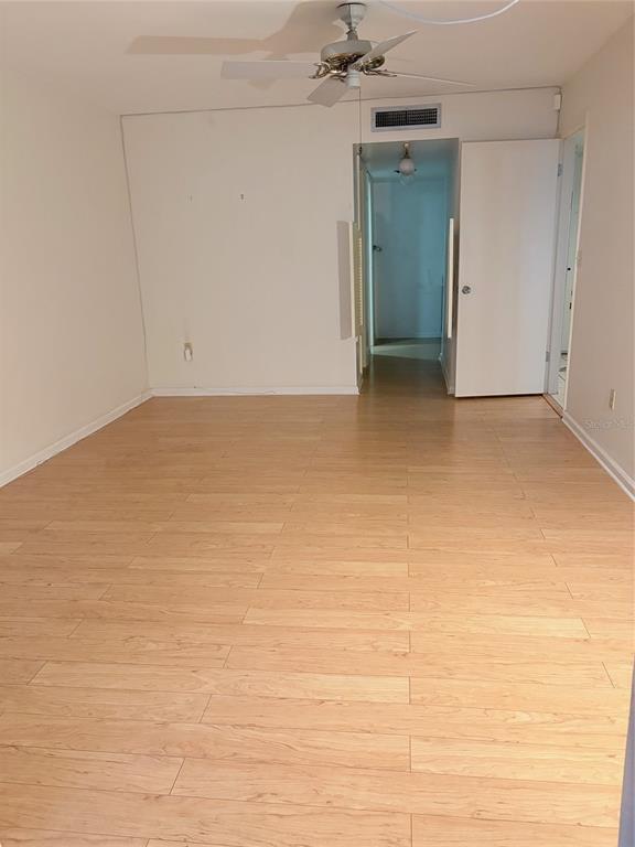 An empty room with light wood-look flooring, a ceiling fan, and an open doorway — 14111 CYPRESS CIRCLE, TAMPA, FL