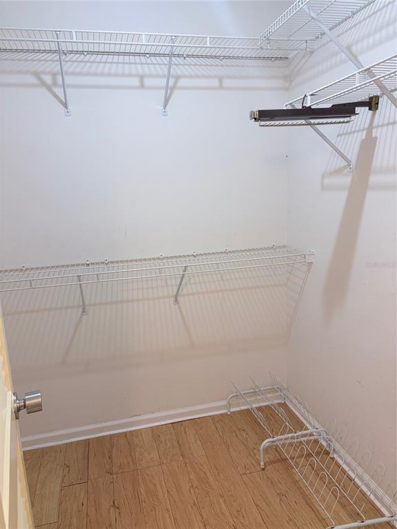 A walk-in closet with white wire shelving, a shoe rack, and light wood-look flooring — 14111 CYPRESS CIRCLE, TAMPA, FL