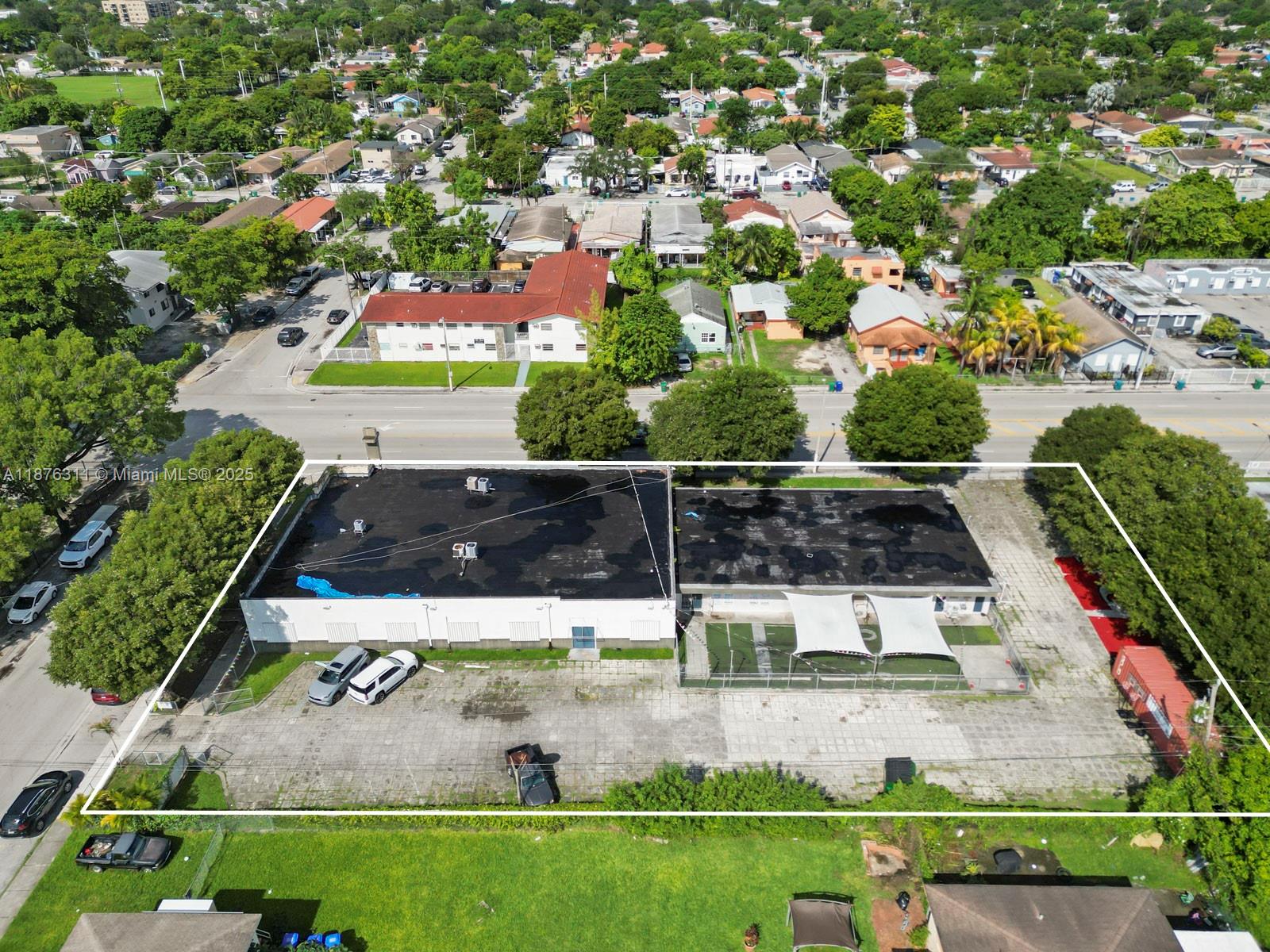 An aerial view shows a commercial building with a large parking lot and fenced yard — 3001 NW 22nd Ave, Miami FL 33142, MIAMI, FL