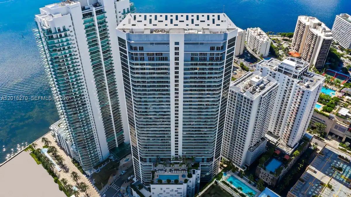 An aerial view shows several tall, modern residential high-rise buildings situated near a waterfront — 1300 Brickell Bay Dr # 2000, Miami FL 33131, MIAMI, FL